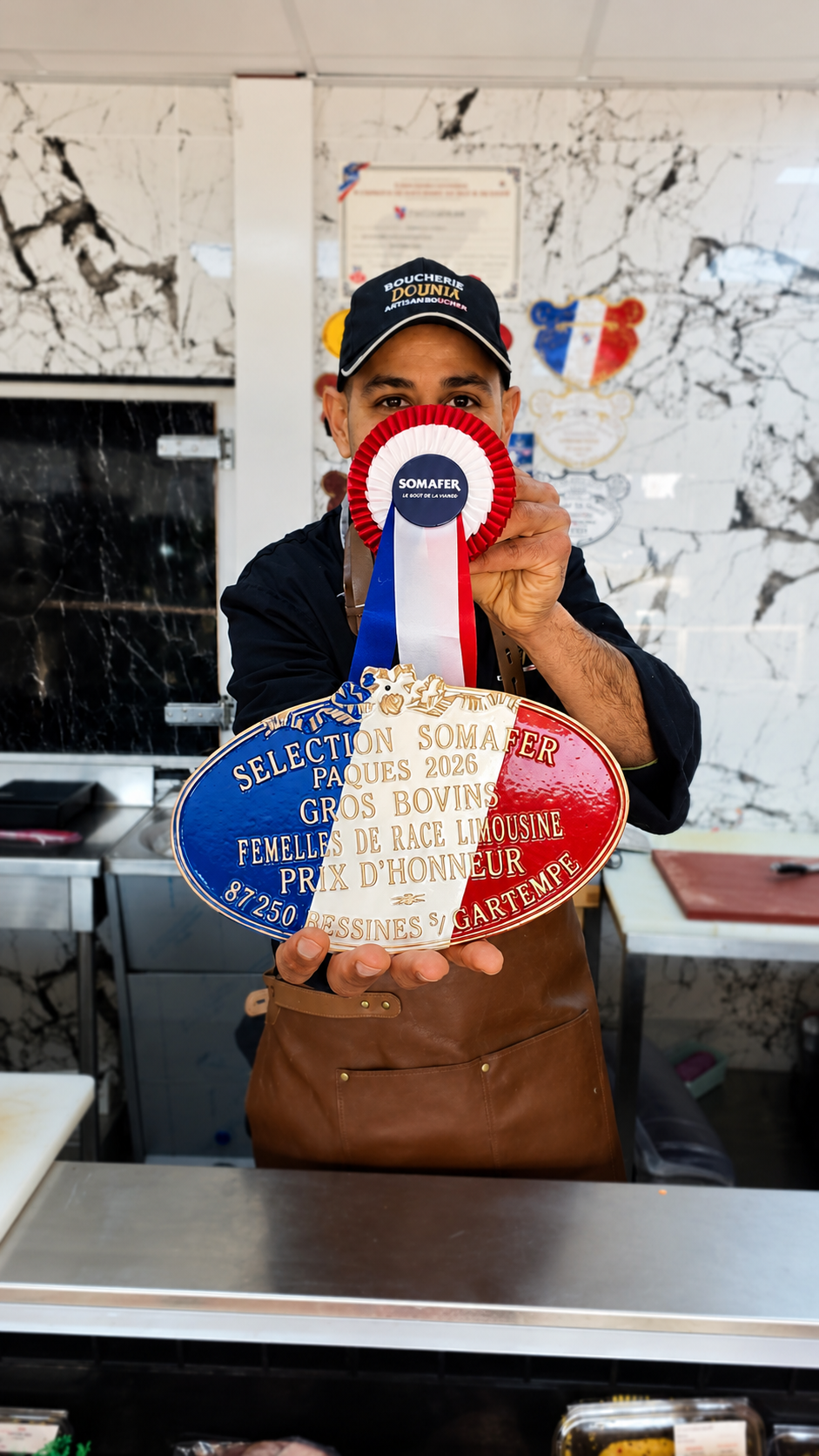 Tarek propriétaire de Boucherie Dounia présentant un prix d'honneur de boucherie